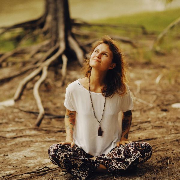 Person in a calm, meditative state in a serene natural environment.